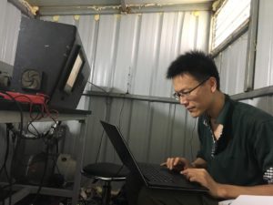 Shenghua Gao working at field site on computer